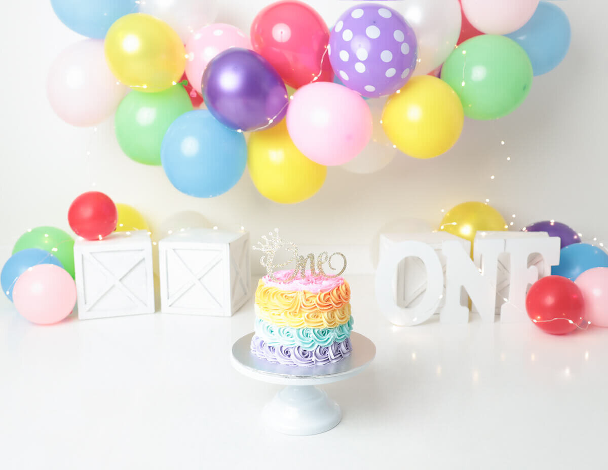 A  colorful cake smash surrounded by balloons in Rochester, NY.