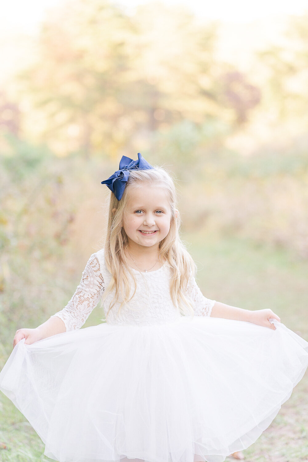 little girl showing off her pretty dress during fall minis taken by a Fairfax, Virginia photographer