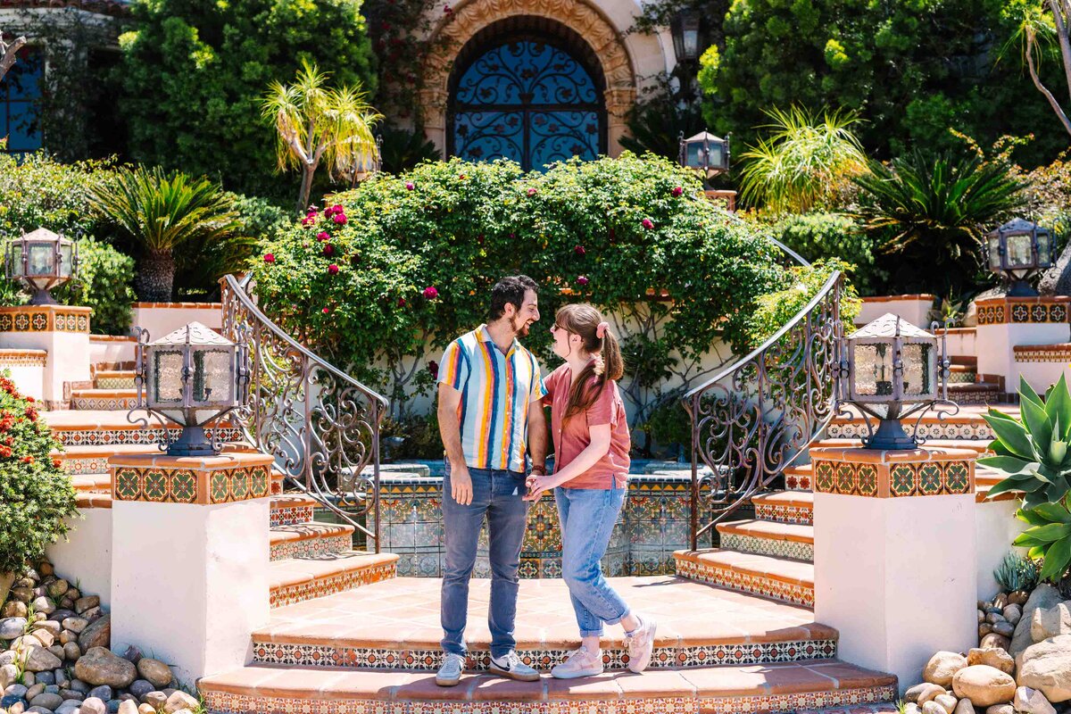 A couple holding hands and looking towards each other.