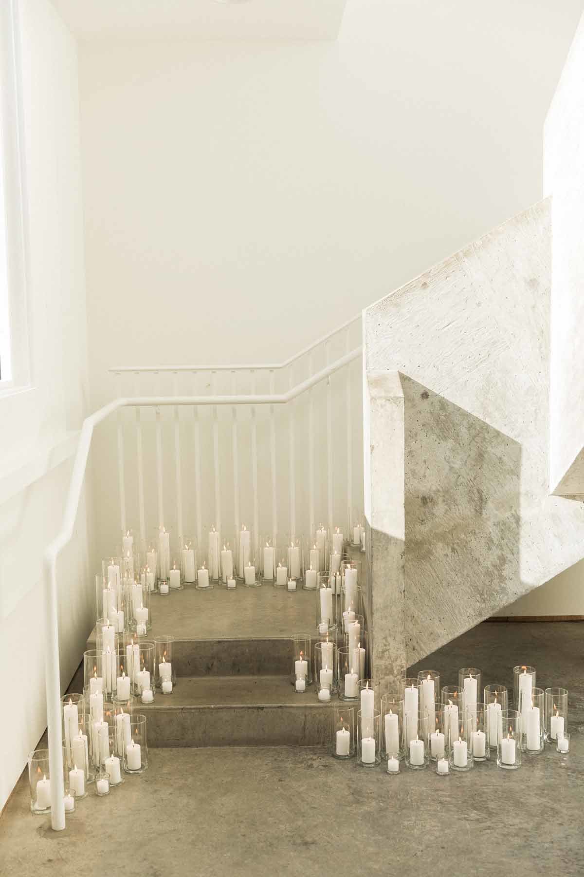 Candlelit stairwell at this simple and striking white wedding at Canvas Event space in Seattle