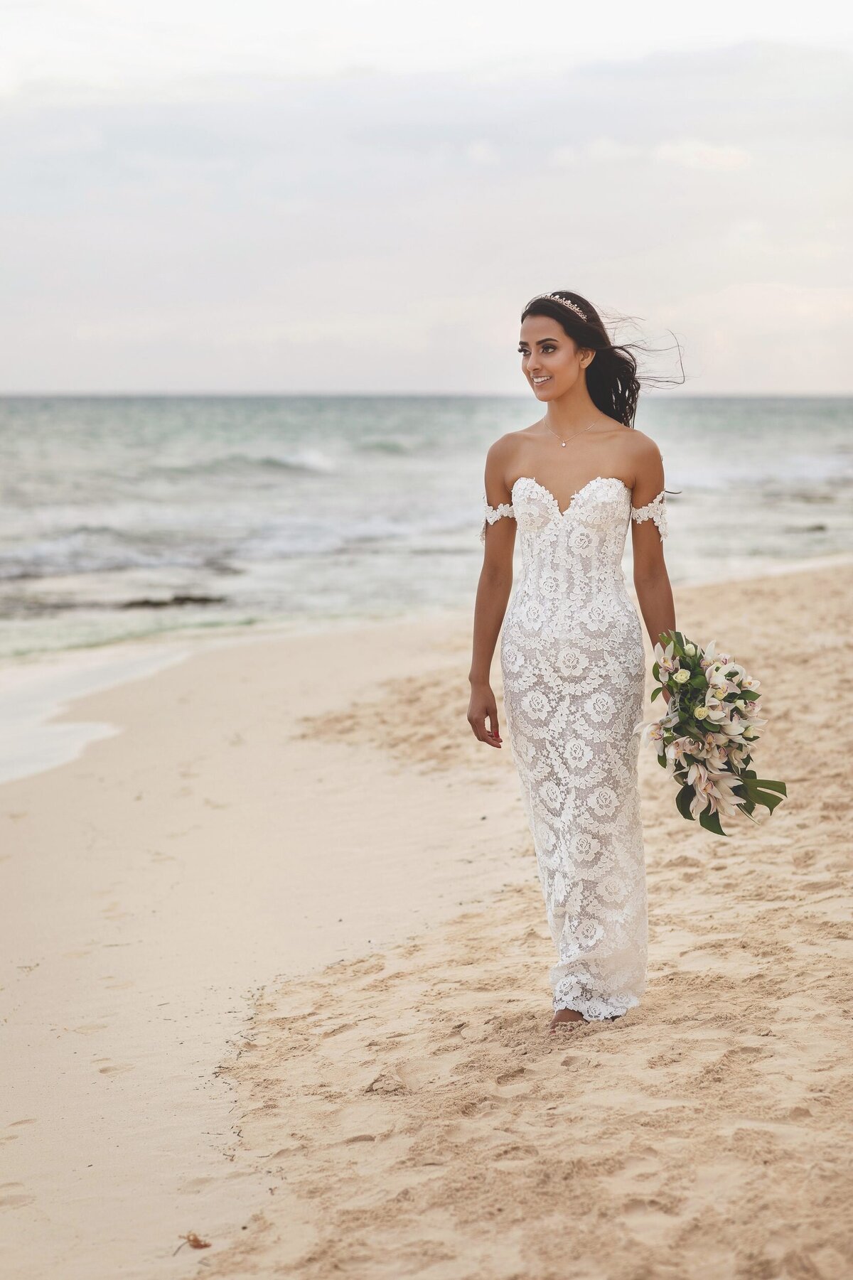 Bride walking on beach in riviera Maya