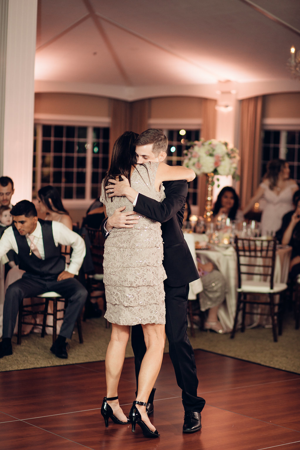 Wedding Photograph Of Groom In Black Suit Hugging a Woman In Light Brown Dress Los Angeles