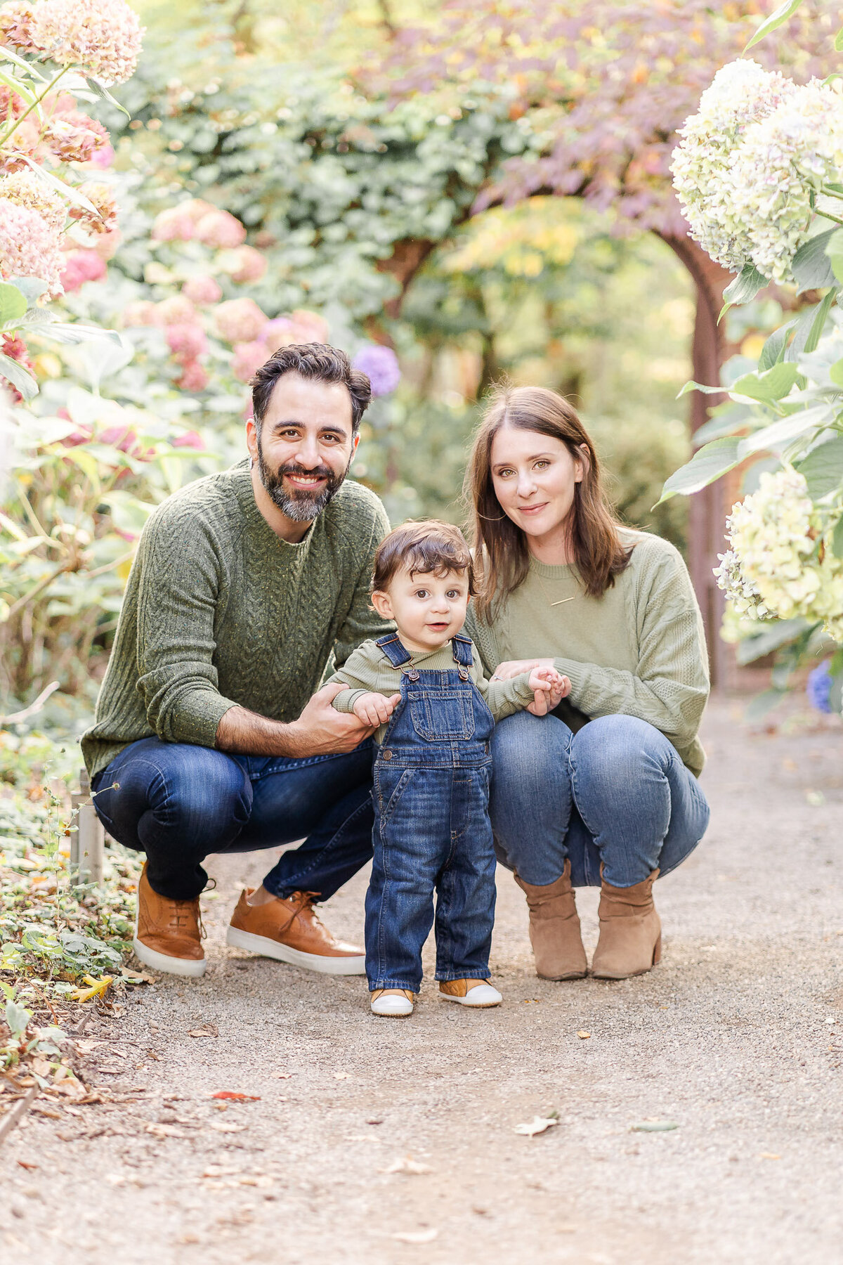 san francisco family crouching down in between flowers with their toddler son