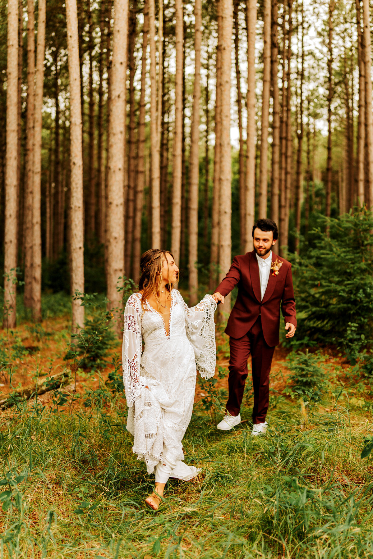 boho elopement couple walking through pine forest