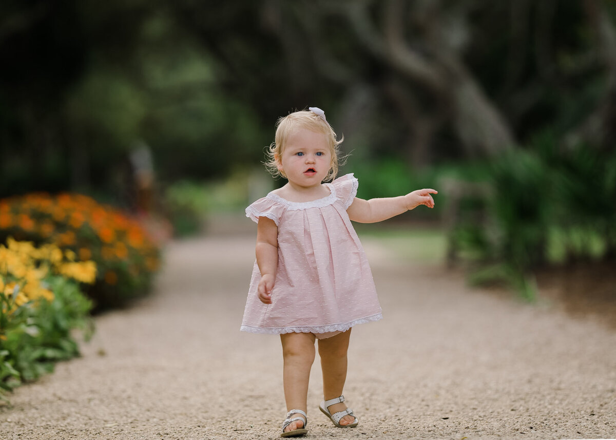 little girl in pink dress walking