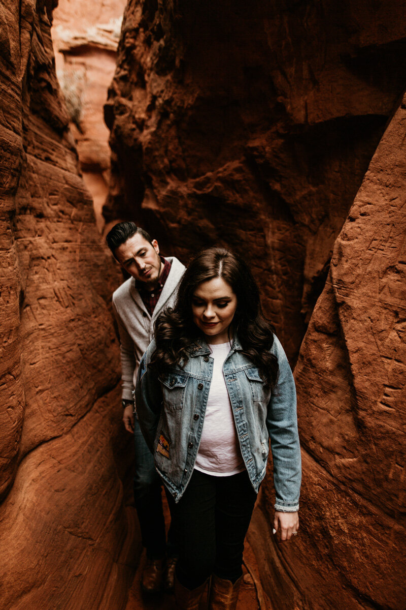 woman leading man through red rock canyon