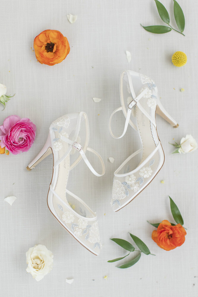 flat lay of bridal shoes with bright flowers