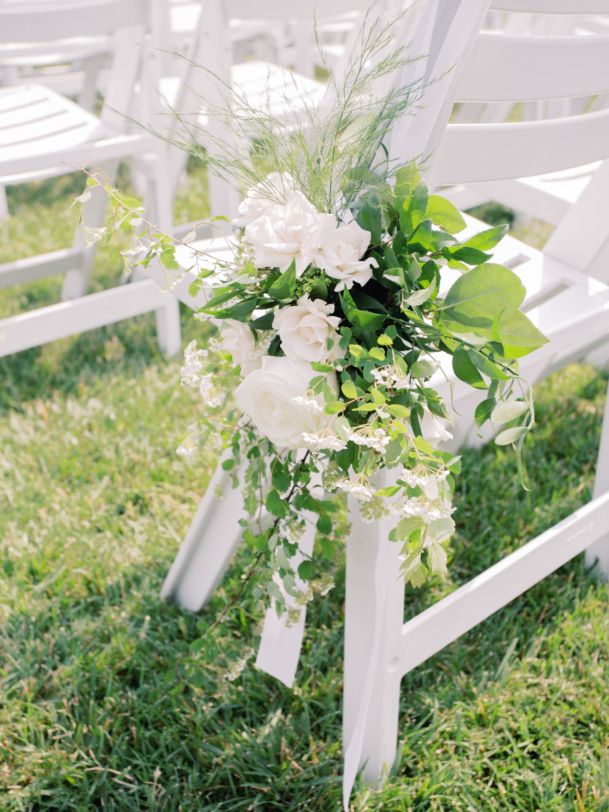 Floral decor for ceremony aisle chairs