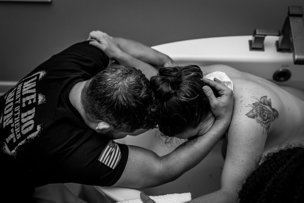 husband wife embrace during water birth