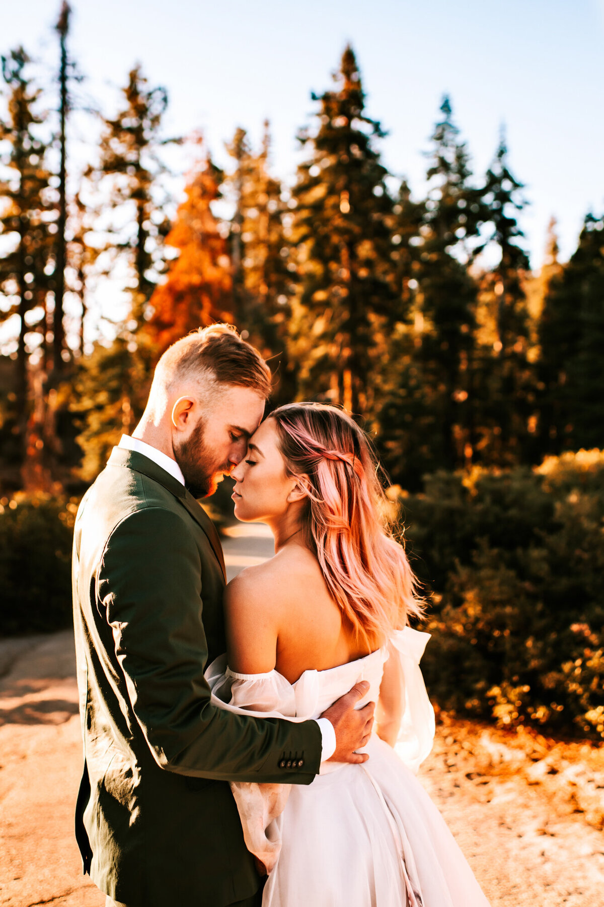 Couples Photography, bride and groom lean into each other nose to nose near the forest