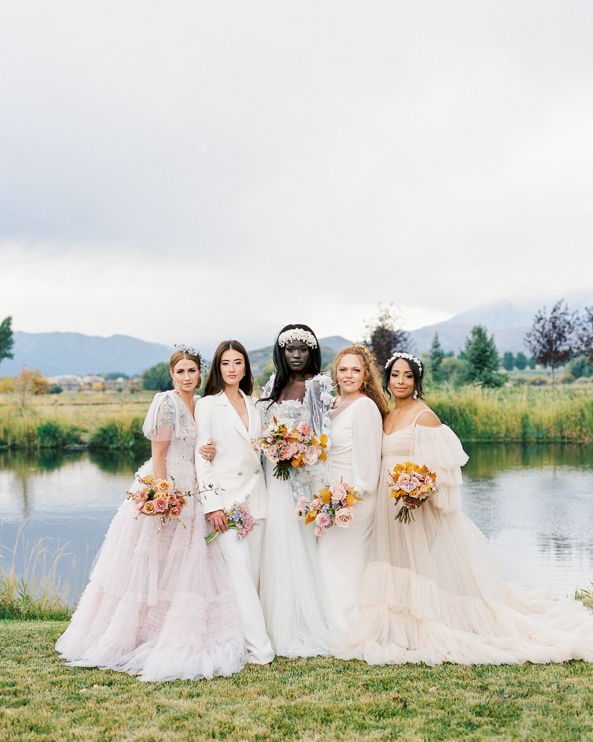 five women wearing romantic bridal gowns