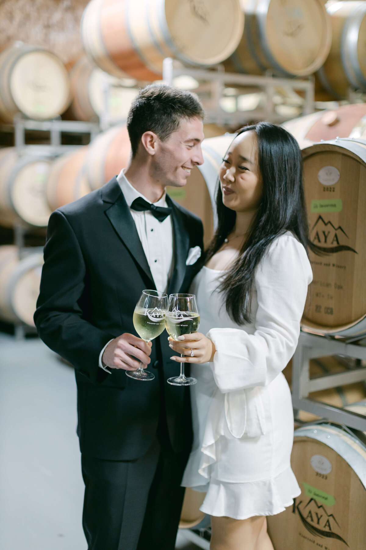 A bride and groom cheers at Kaya Vineyards.