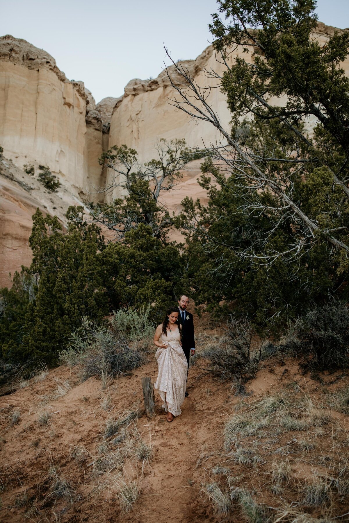 bride and groom walking from a New Mexico canyon
