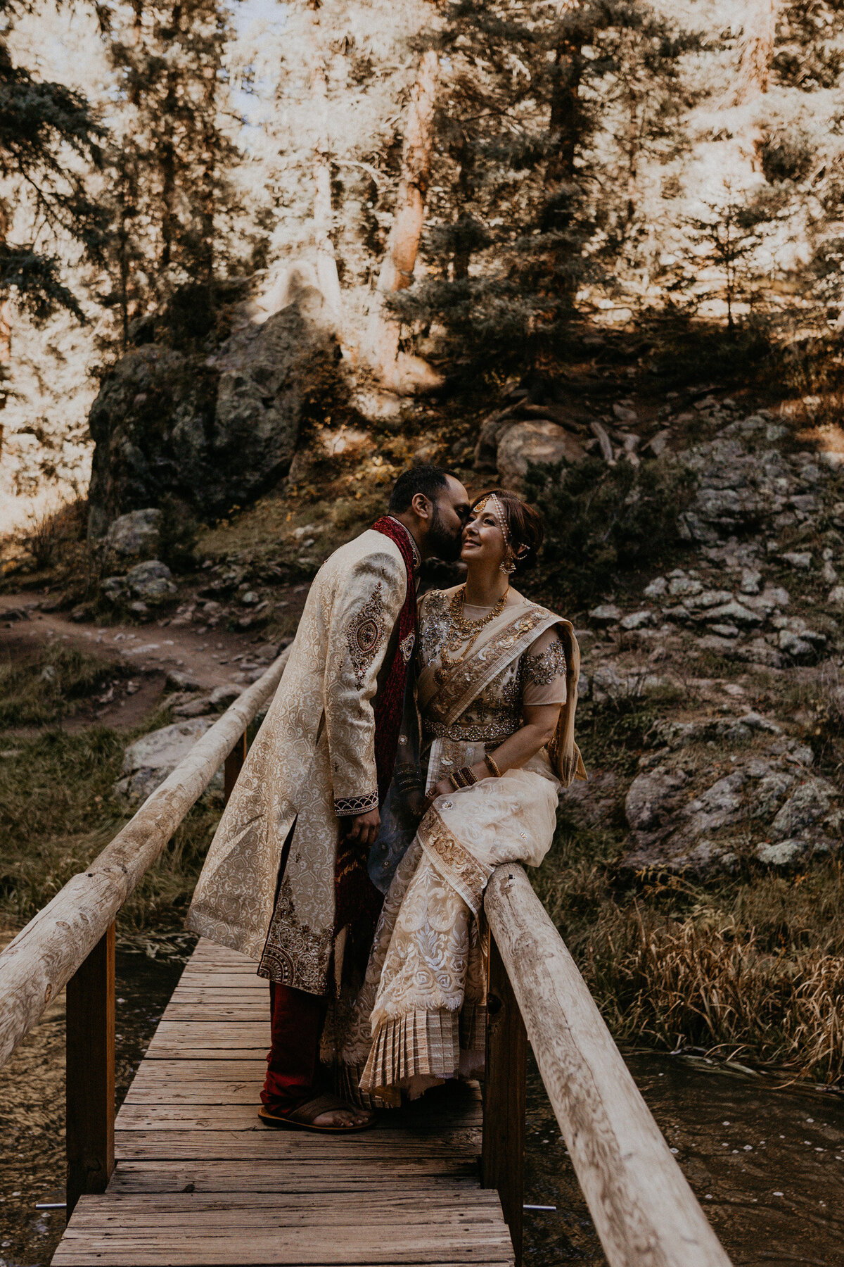 bride and groom in Indian attire on a bridge