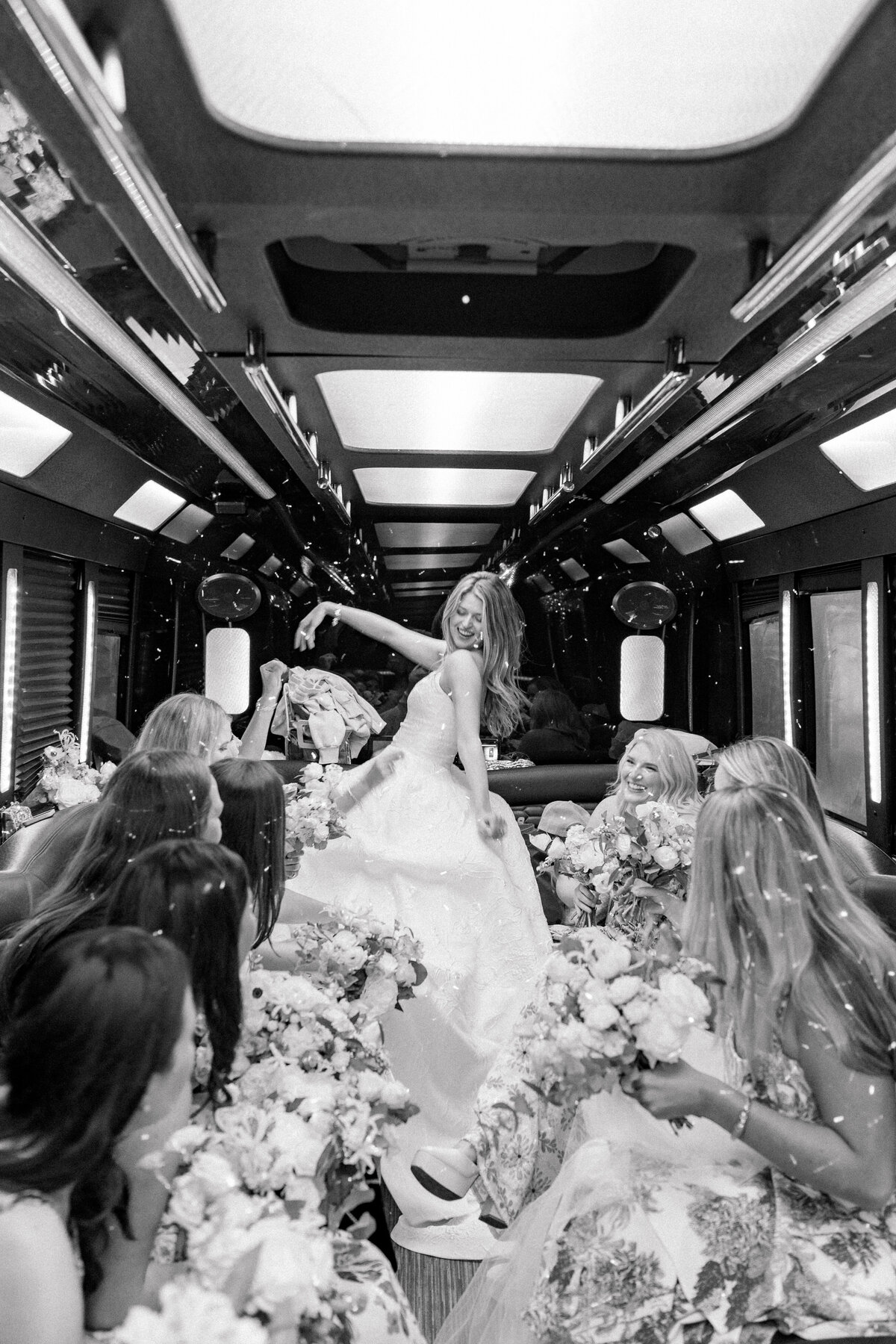 Bride arrives to her wedding on a party bus with all of her friends. Kiawah River Course wedding. Kailee DiMeglio Photography. Black and white candid wedding photographer.