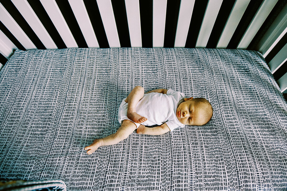 baby boy with one leg out in his crib
