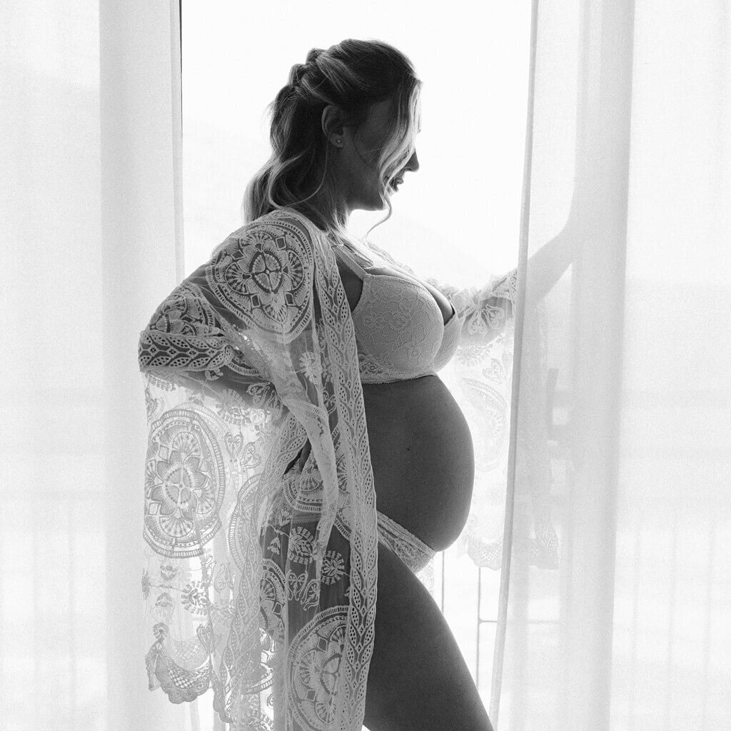 Black and white photo of maternity session wearing a beautiful lace coverup.