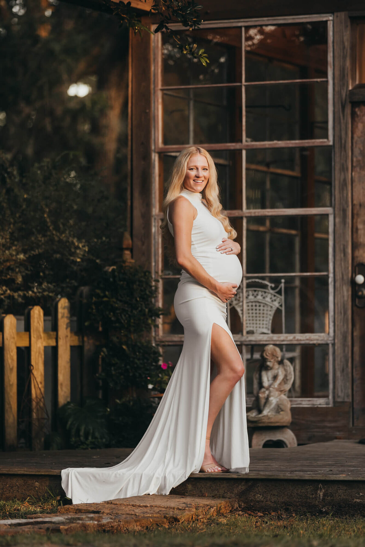 pregnant woman stands in front of greenhouse for allyson blankenburg for maternity photos.