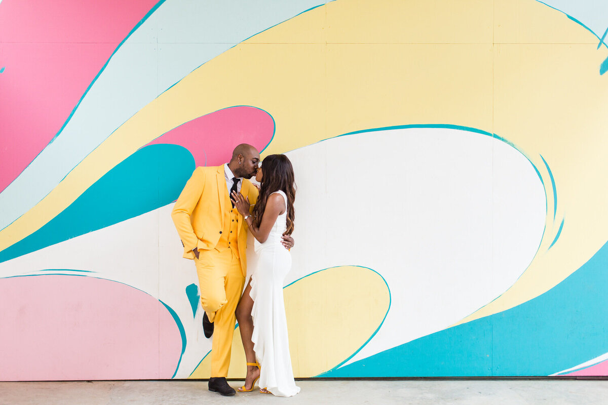 engaged couple standing by graffiti wall at ponce city market