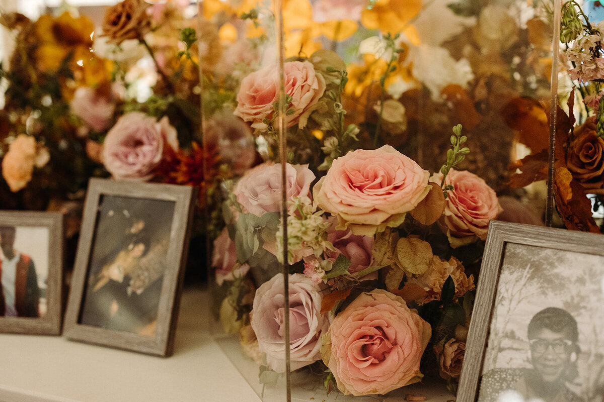 Elegant window arrangements and candle moments create a warm autumnal setting in hues of dusty rose, burgundy, taupe, mauve, and lavender florals composed of roses, raintree pods, ranunculus, spray roses, copper beech, and fall foliage. Design by Rosemary and Finch in Nashville, TN.