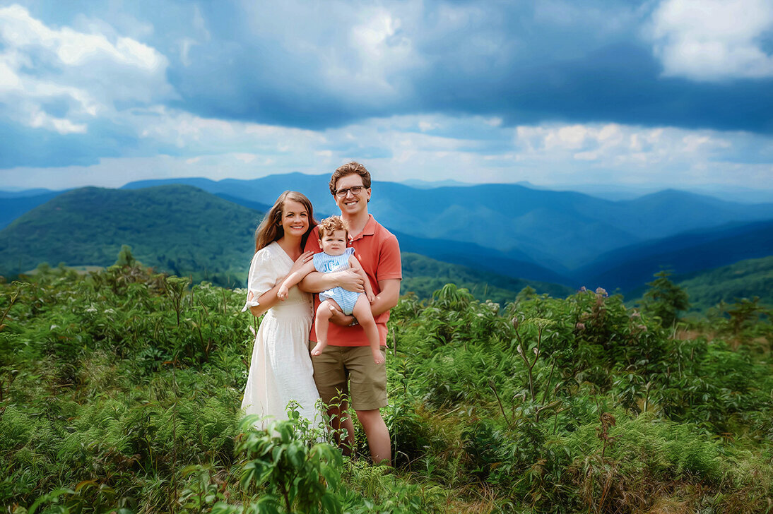Family poses for portraits on a mountain top in Asheville, NC.