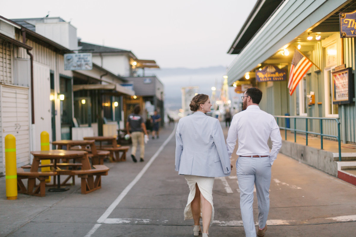 Bride and groom walk in harbor at dusk at Santa Barbara Yacht Club Wedding