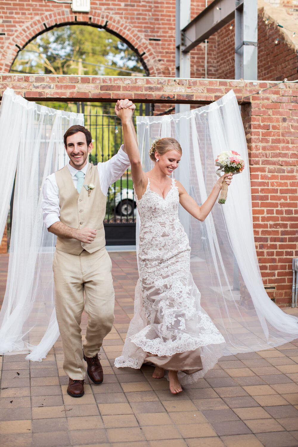 happy bride and groom walking into outdoor reception