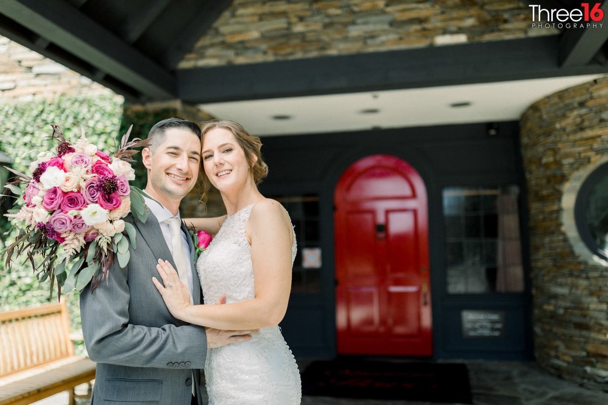 Newly married couple cozy up for photos in front of the red door entrance at the Summit House Restaurant