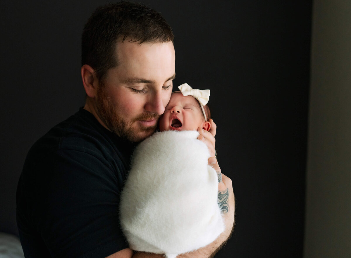 baby-yawning-while-dad-holds-her