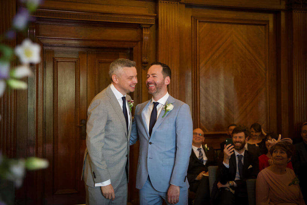 Grooms laughing together during thier ceremony