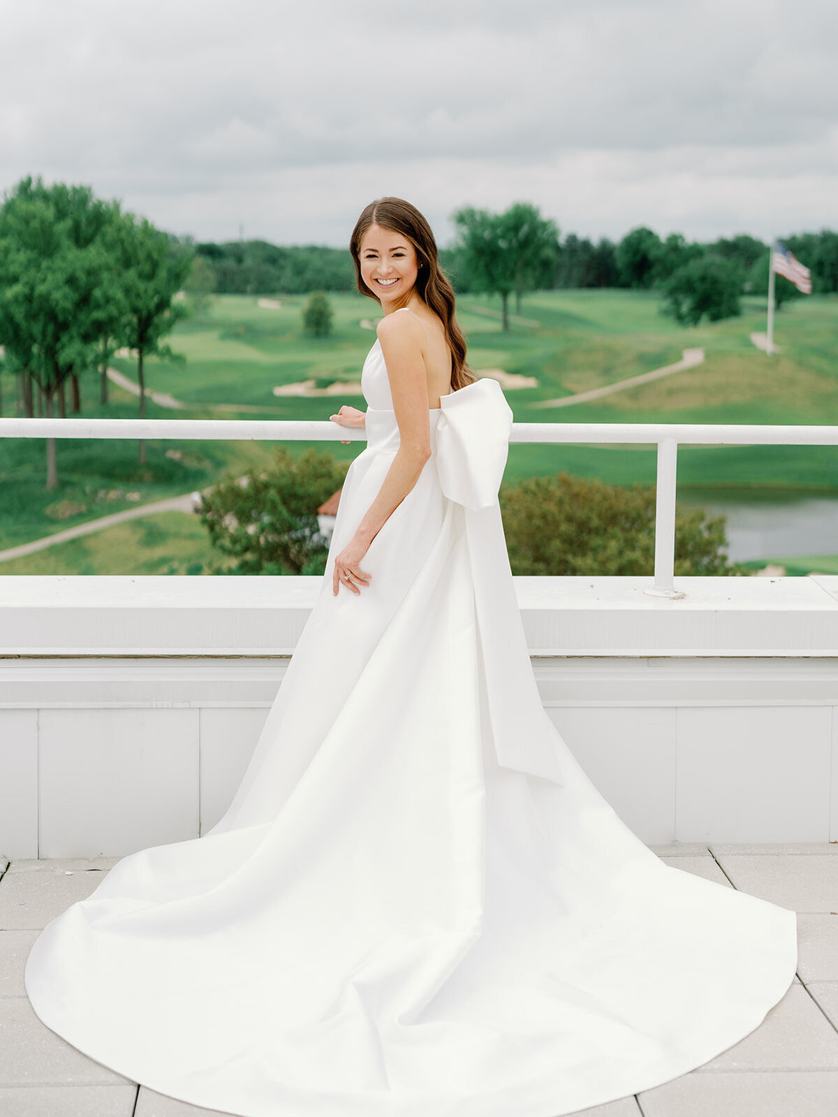 A bride poses for a portrait on the balcomy of congressional country club