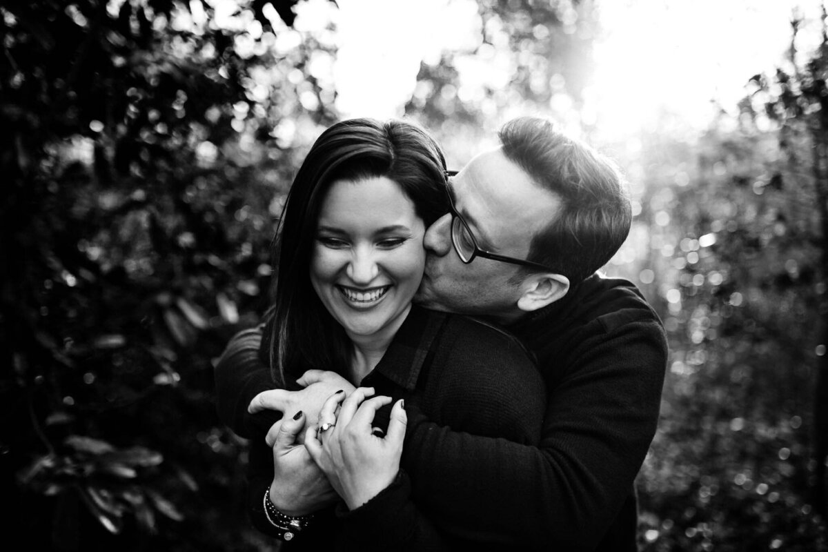 Luxury Wedding Portraits by Moving Mountains Photography in NC - Black and white photo of a man kissing a woman's cheek.