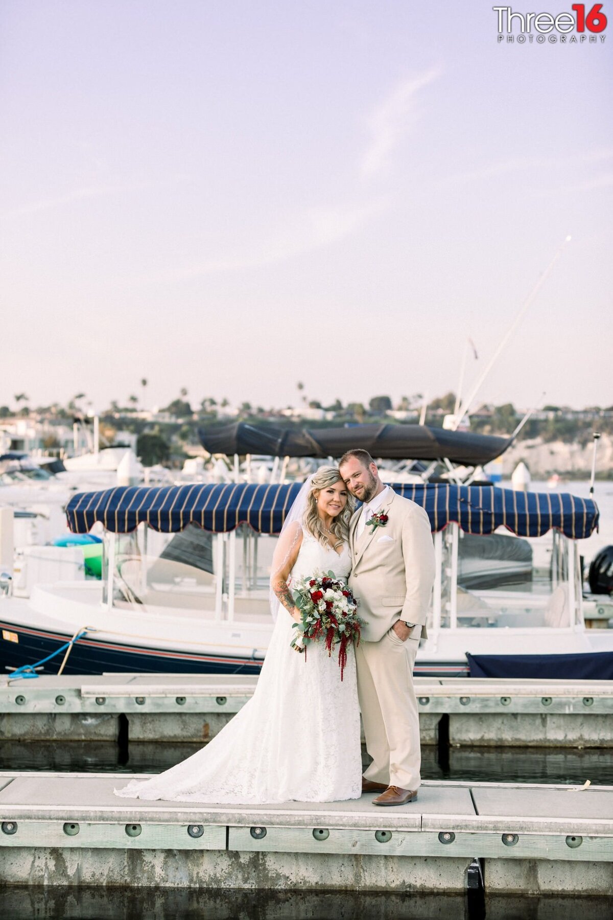 Bride and Groom pose together on the boat docks at Newport Dunes
