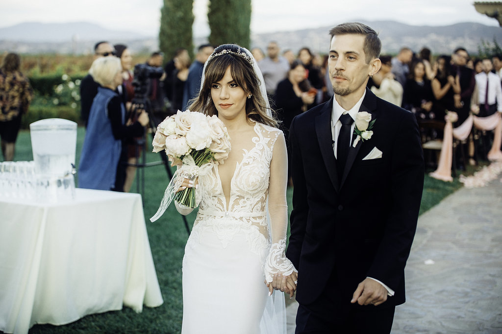 Wedding Photograph Of Bride Carrying a Bouquet While Walking With Groom Los Angeles