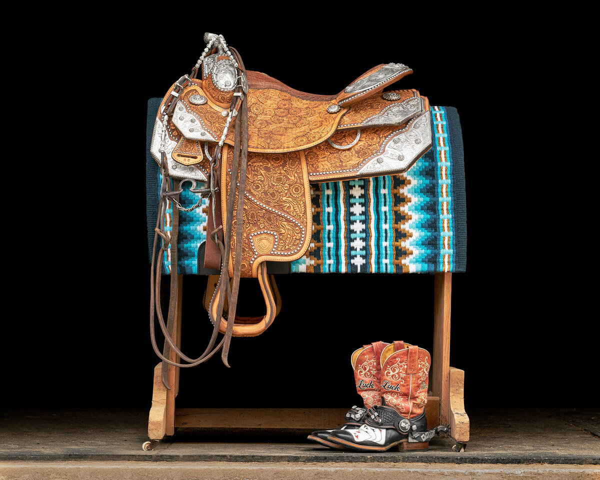 Show saddle, pad, bridle, and boots captured against a black background