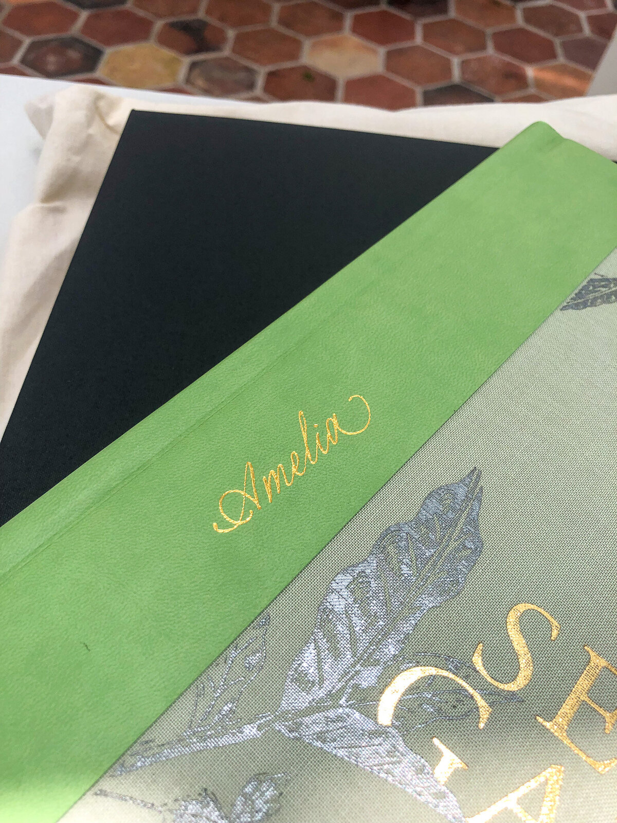 green leather book with name embossed in gold foil