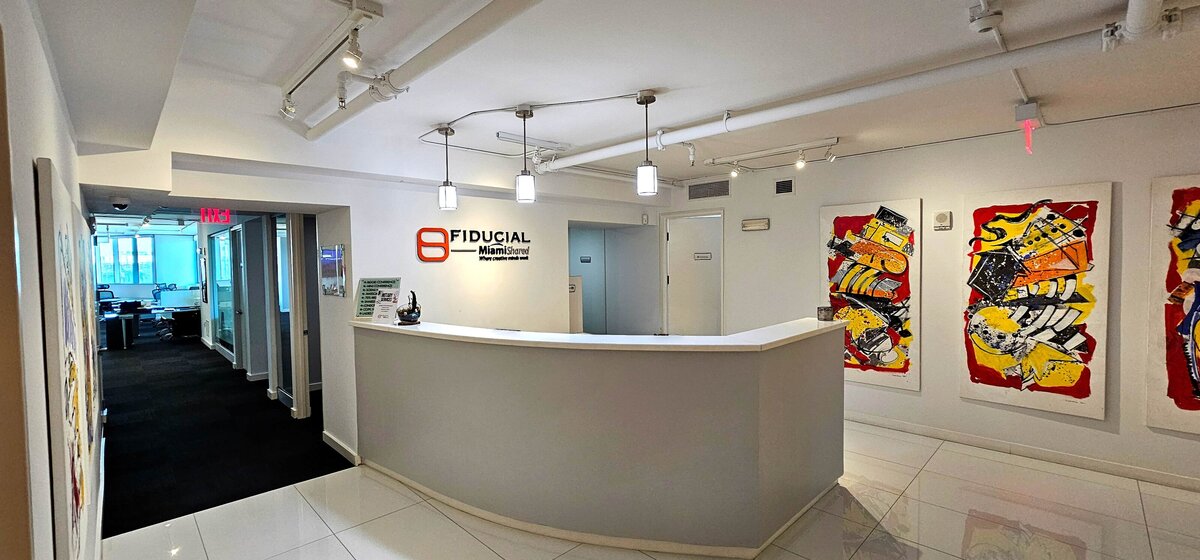 MiamiShared reception desk with the Fiducial logo behind it