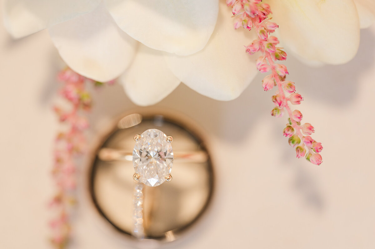 A black wedding band with a oval diamond engagement ring by JoLynn Photography