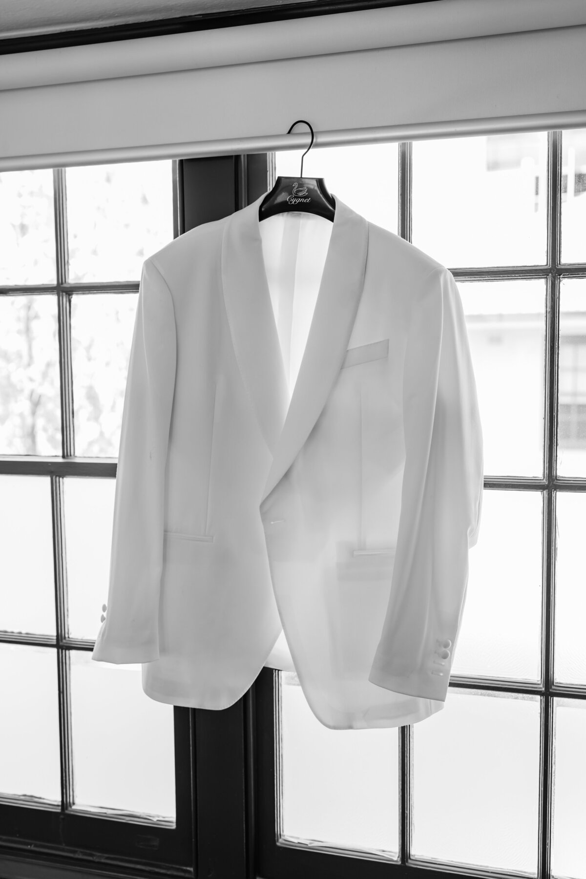 White groom suit hanging in the window
