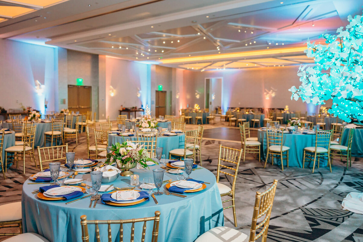 Details of a ballroom set up with blue lights and matching linens for a mitzvah
