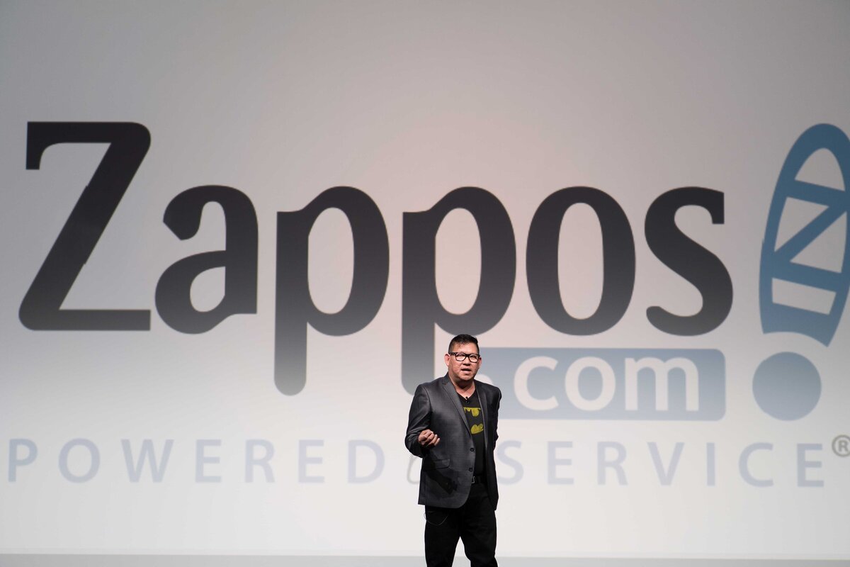 Executive from Zappos speaks onstage during a presentation