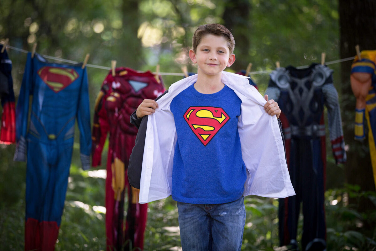 boy-with-superman-shirt-and-costumes-on-closthes-line
