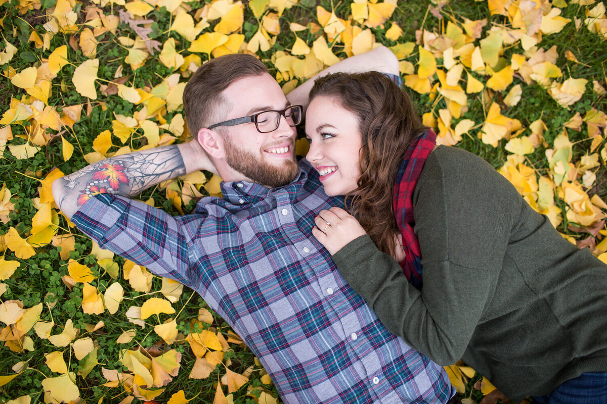 hipster couple laying in fall leaves