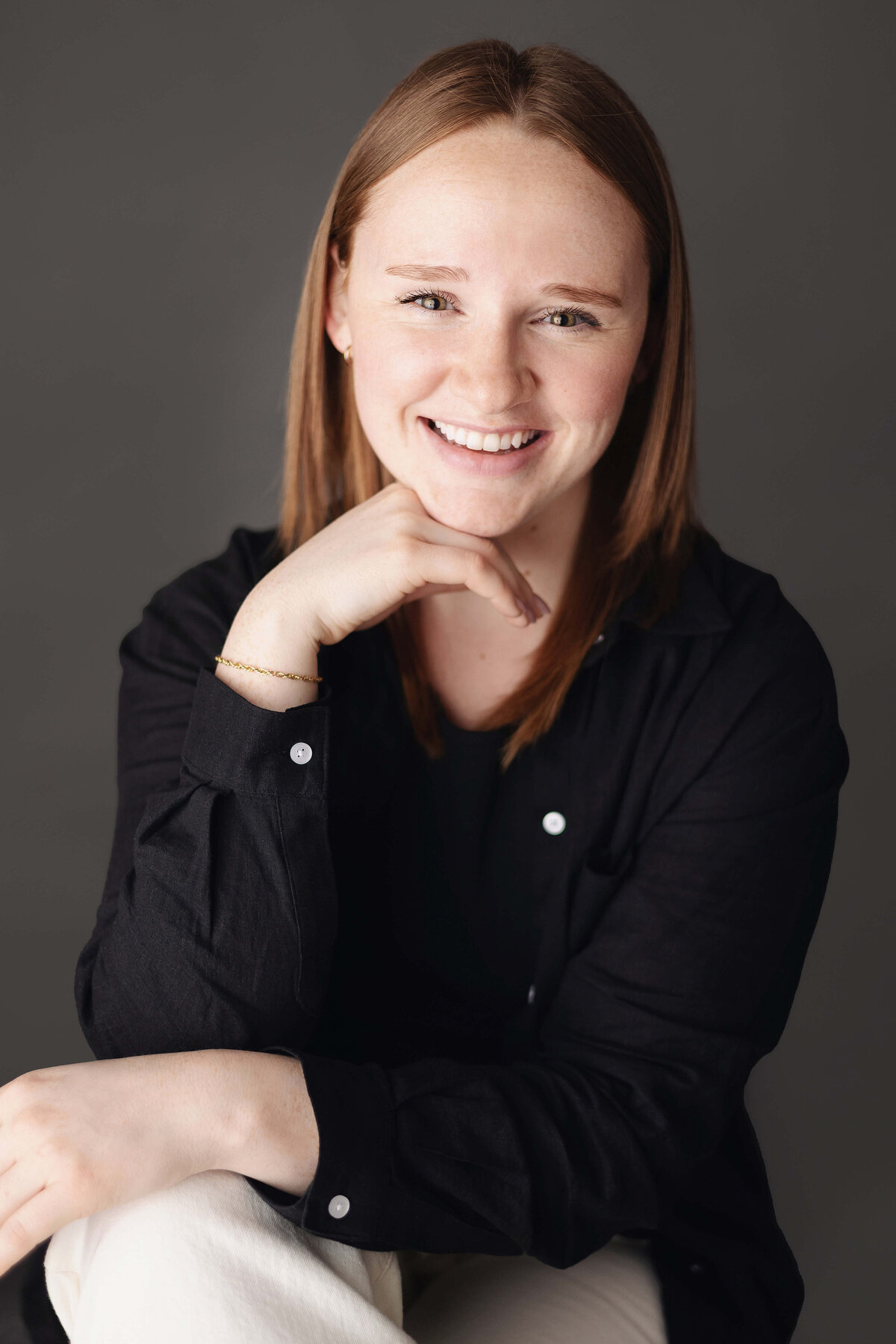 headshot for woman in black shirt with gray background
