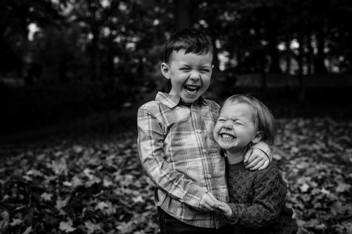 Brother and sister hugging during family session in the fall