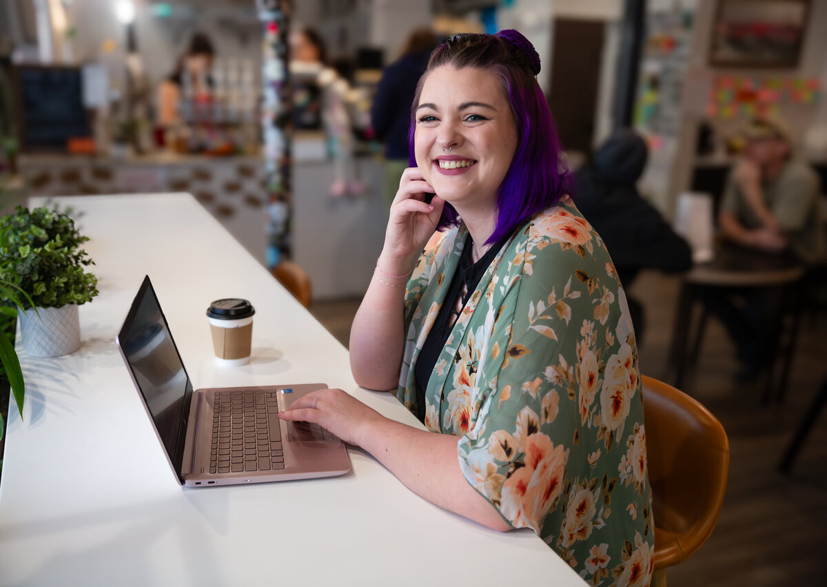 The Social Media Manager for Mermaid Kove Marketing, Danielle Murphy, works at her laptop for her personal branding session with Ingrid Berrios Photography at CoffeeBar Bel Air in Maryland.