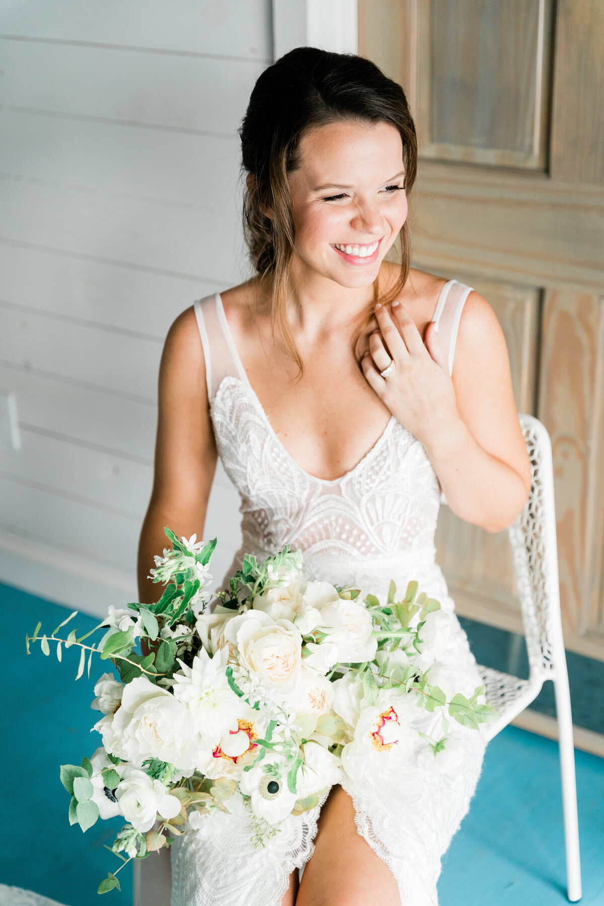 Bride sitting with white bouquet