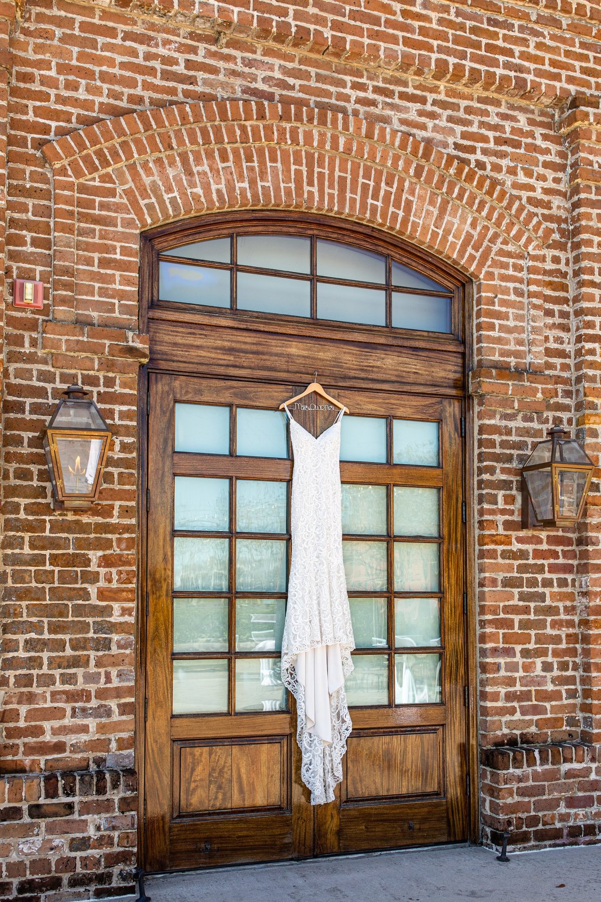 wedding dress hanging on the door of the charles morris center in savannah