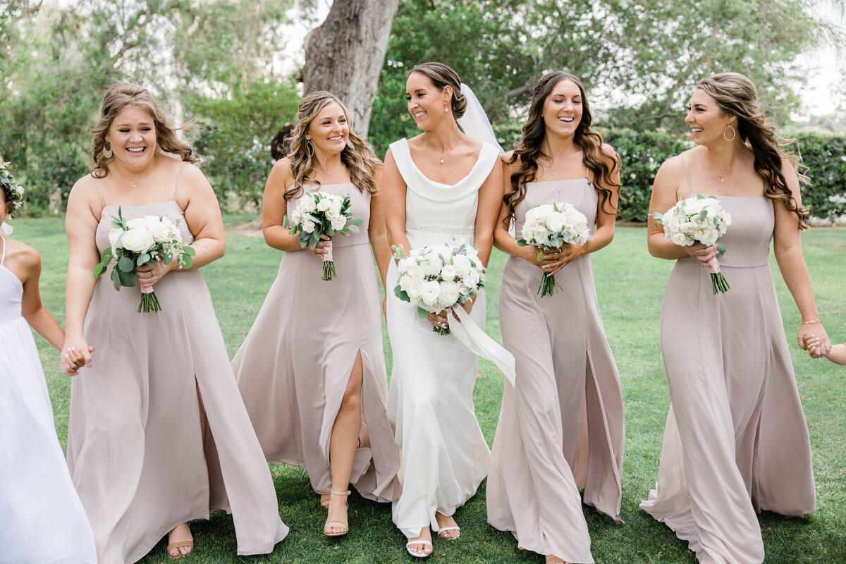 bride with bridesmaids laughing  and walking