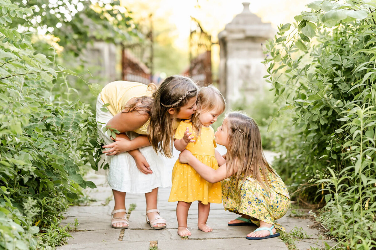 Three young sisters snuggling close at Chicago family photography location in Geneva, IL.